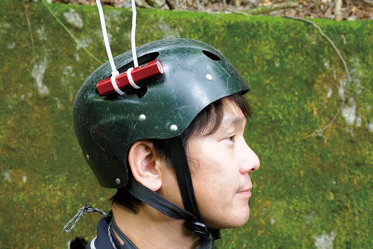 ヘルメットに、防水ライトを固定。スイッチが手探りでオンオフできるのが理想。