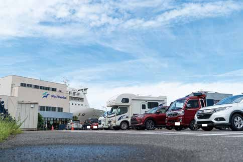 フェリーターミナルで乗船を待つキャンピングカーと乗用車